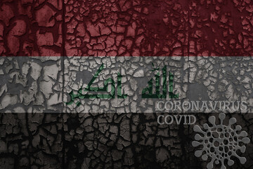 Obraz premium flag of iraq on a old metal rusty cracked wall with text coronavirus, covid, and virus picture.