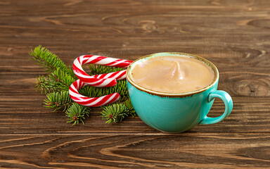 Christmas composition. Blue cup with hot chocolate, fir branches, lollipop candy on wooden...