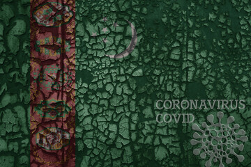 flag of turkmenistan on a old metal rusty cracked wall with text coronavirus, covid, and virus picture.