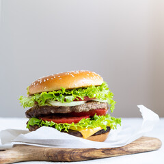 Double cheeseburger with veal cutlets, tomatoes, lettuce leaves and cucumbers. Fast food.