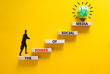 Power of social media symbol. Wooden blocks with words The power of social media. Beautiful yellow background, copy space. Businessman icon, light bulb. Business, power of social media concept.