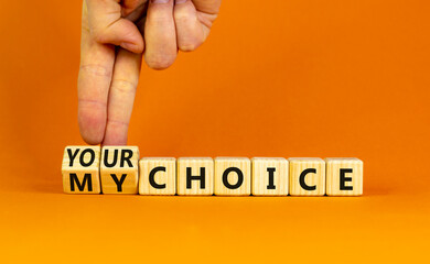 My or your choice symbol. Businessman turns wooden cubes and changes words 'my choice' to 'your choice'. Beautiful orange background, copy space. Business and my or your choice concept.