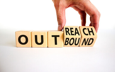 Outreach or outbound symbol. Businessman turns wooden cubes and changes the word 'outbound' to...