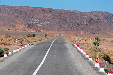 For God, the king and the homeland written on a mountain in the Middle Atlas in Morocco with the moroccan flag