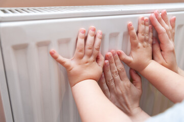 Baby hands measure battery temperature. Usually, the heating season in Ukraine starts either from...
