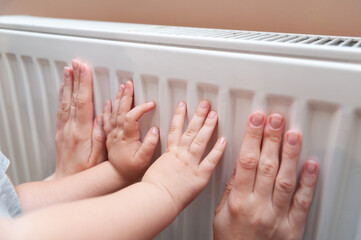 Baby hands measure battery temperature. Usually, the heating season in Ukraine starts either from...