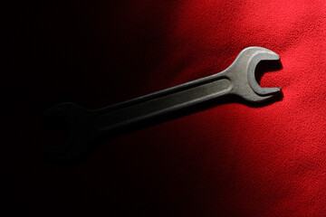 The horn wrench is partially illuminated on a red fabric background