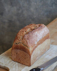 homemade whole wheat bread, tin loaf, on a wooden board on the kitchen table