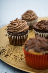 chocolate cupcakes on a golden plate with crumbs