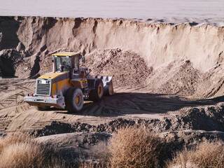 Tractor loader at work in a sand pit.