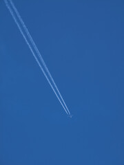 Airplane with a white train against a clear blue sky.