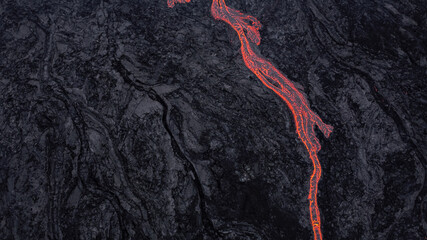hot lava running on solidified black lava