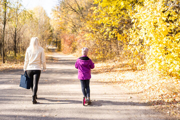 mother and daughter ride the scooter in the park