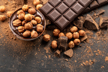 chocolate bar with hazelnuts, handmade sweets. Composition of bars dark chocolates hazelnuts on a...