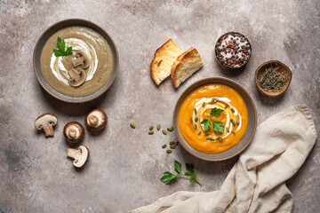 Pumpkin and mushroom cream soup in a bowl on a brown rustic background. Vegan or vegetarian lunch. Warm winter or autumn soup. Top view, flat lay. Textured object