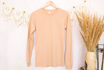 Peach sweatshirt mockup on a hanger with pampass grass

