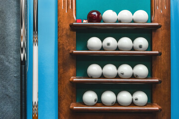 Shelf with white balls and billiards equipment