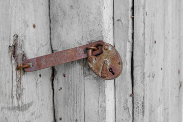 Wooden door of an old wooden church. Hanging rusty lock