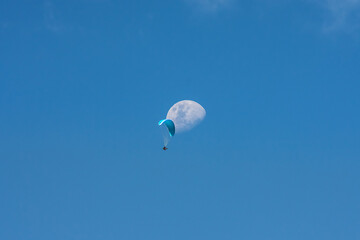 Unidentified paraglider flying with the moon in the background