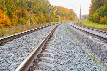 Fototapeta na wymiar Photo of the railway. Steel rails, concrete sleepers, gravel filling. Autumn urban landscape. Railway landscape