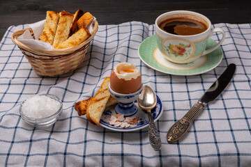 breakfast with an egg on a stand and cup of coffee