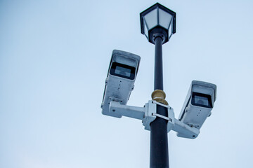 two surveillance cameras on a lamppost
