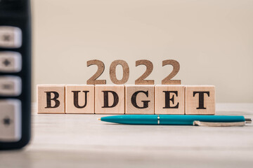 Budget 2022 concept. 2022 budget wooden cubes, calculator and a pen on wooden office table. 2022...