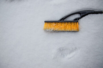 brush for cleaning car lies on the snow
