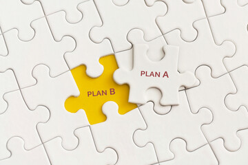 White details of puzzle with the text Plan A and Plan B on yellow background.