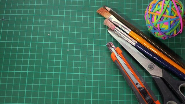 Craft supplies for art projects on a green cutting mat