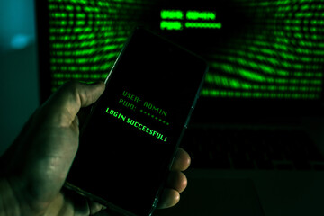 Hand with smartphone doing successful login in a digital network. Display with green numbers in...