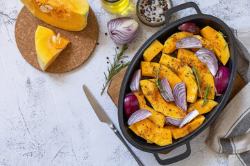 Raw pumpkins slice with rosemary and purple onion, baking fresh healthy food with spice on a gray stone background. Keto or paleo diet veggie vegan or vegetarian. Top view  background. Copy space.