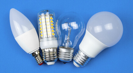 New and old light bulbs together, blue background. Energy saving concept. Flat lay, top view photo