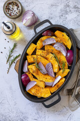 Raw pumpkins slice with rosemary and purple onion, baking fresh healthy food with spice on a gray stone background. Keto or paleo diet veggie vegan or vegetarian. Top view flat lay background.