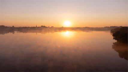 Beautiful foggy morning. Fog over autumn lake at sunrise moment. Wide panorama.