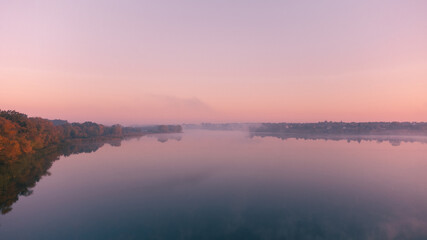Beautiful foggy morning. Fog over autumn lake at sunrise moment. Wide panorama.