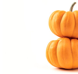Two orange pumpkins on top of each other on white background. Copy space on the left hand side of pumpkins