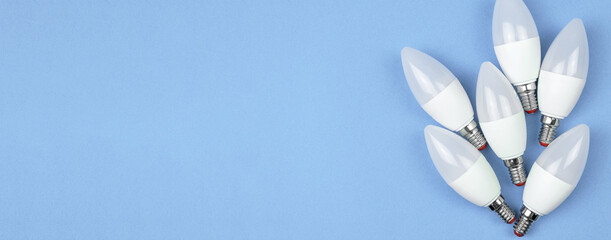 Eco friendly LED light bulbs, pastel blue background. Energy saving concept. Banner flat lay, top view, copy space photo