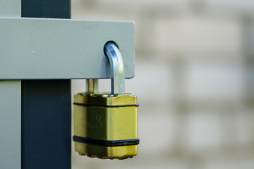 locked padlock with yellow body hangs in the door loop