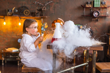 Toddler smiling baby girl in funny glasses conduct interesting chemical experiments with smoke at...