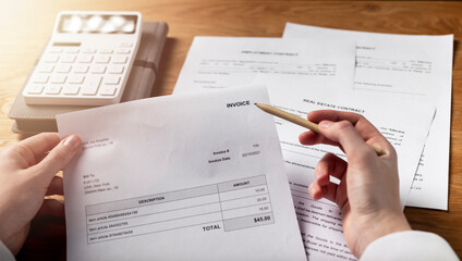 Invoice in hands. Business paper bill document over office desk.