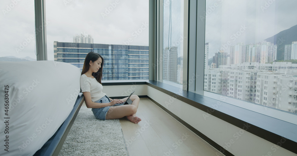 Wall mural woman sit on floor and use of tablet computer