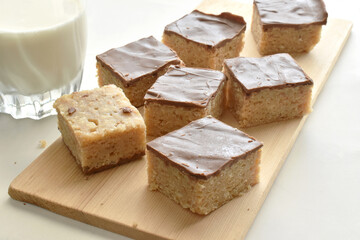 Chocolate caramel rice crispy treats on a bamboo chopping board.