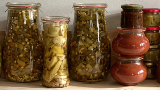 Jars with homemade preserved food. Assortment of canned vegetables. Camera slide.