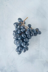 A bunch of black grapes on a light background