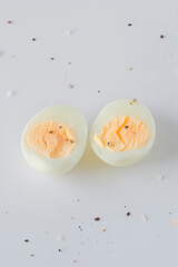 Two halves of a boiled egg on a light background.
