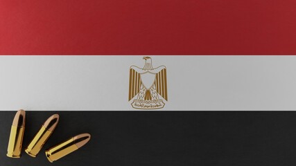 Three 9mm bullets in the bottom left corner on top of the national flag of Egypt