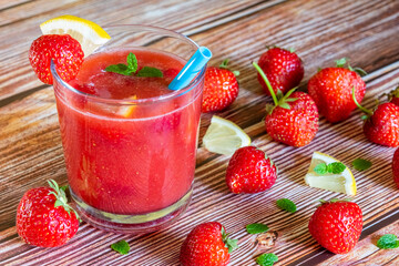 Glass of fresh strawberry smoothie on wooden background