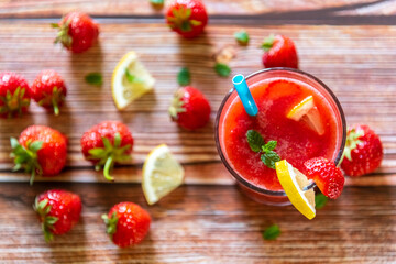 Glass of fresh strawberry smoothie on wooden background