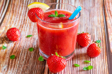 Glass of fresh strawberry smoothie on wooden background
